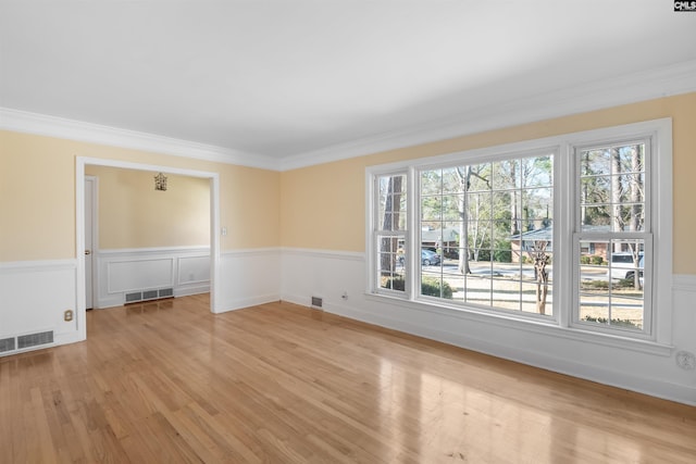 empty room with a healthy amount of sunlight, light wood-type flooring, and visible vents