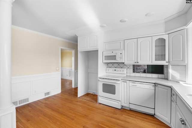 kitchen featuring light countertops, visible vents, ornamental molding, white cabinets, and white appliances