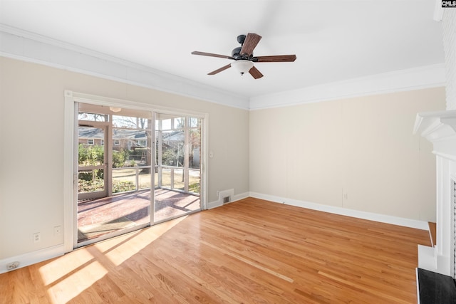 unfurnished living room with a fireplace, ornamental molding, ceiling fan, light wood-type flooring, and baseboards