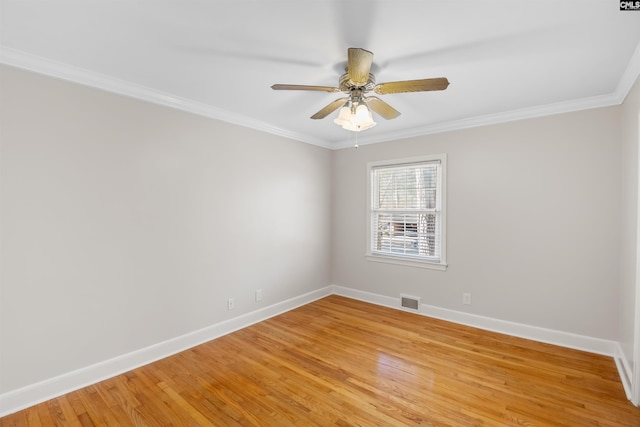 unfurnished room featuring crown molding, light wood-style flooring, visible vents, and baseboards