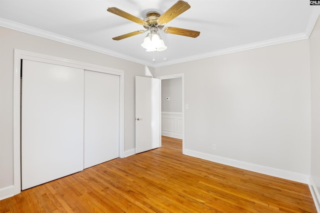 unfurnished bedroom with light wood finished floors, baseboards, ceiling fan, ornamental molding, and a closet