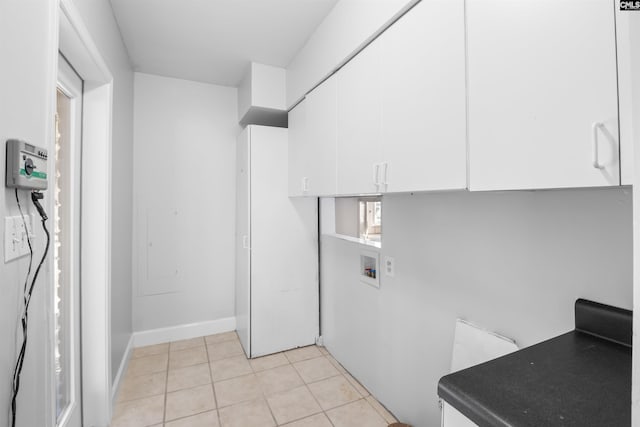 laundry room featuring cabinet space, hookup for a washing machine, baseboards, and light tile patterned floors