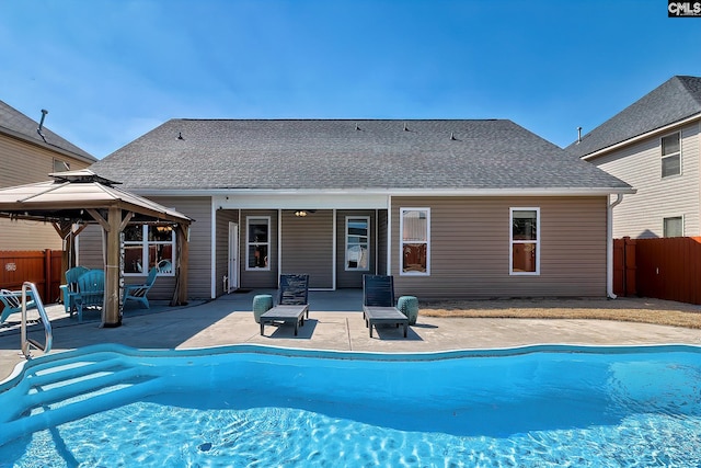 rear view of property with a patio, a gazebo, fence, and a fenced in pool