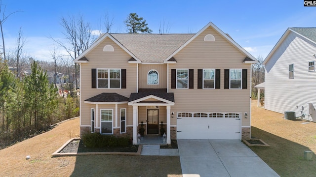 view of front facade featuring driveway, a garage, stone siding, a front lawn, and central AC