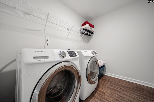 washroom with dark wood-type flooring, laundry area, independent washer and dryer, and baseboards