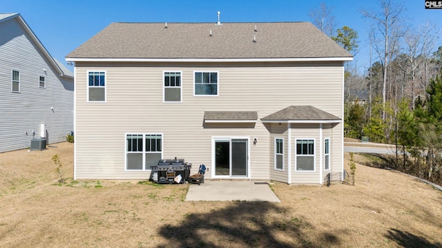 rear view of property featuring a patio area, central AC unit, a lawn, and roof with shingles