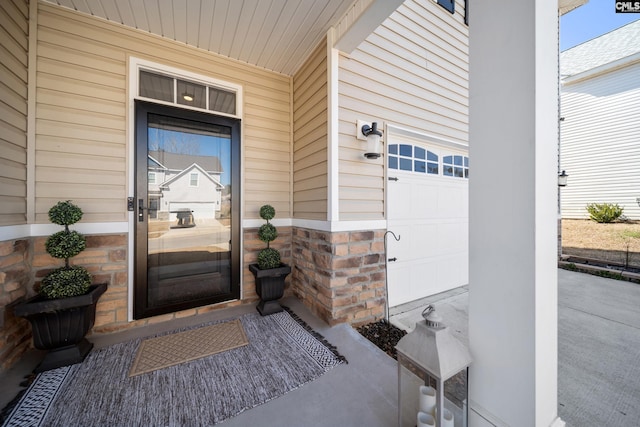 entrance to property featuring an attached garage and stone siding