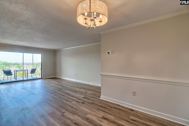 unfurnished room featuring ornamental molding, a textured ceiling, wood finished floors, a chandelier, and baseboards