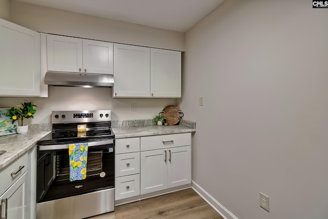 kitchen with electric stove, light countertops, under cabinet range hood, and white cabinetry