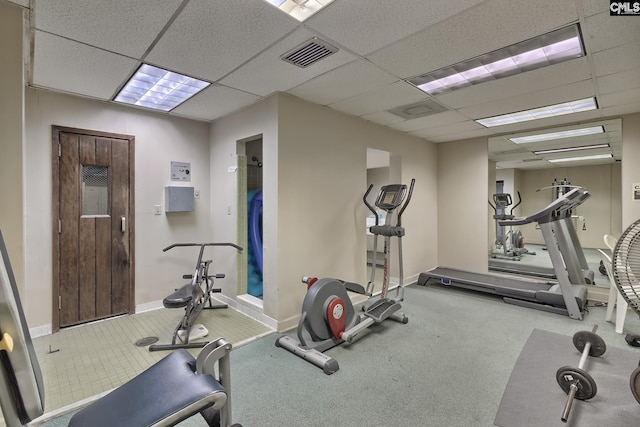 workout area with a paneled ceiling, visible vents, and baseboards