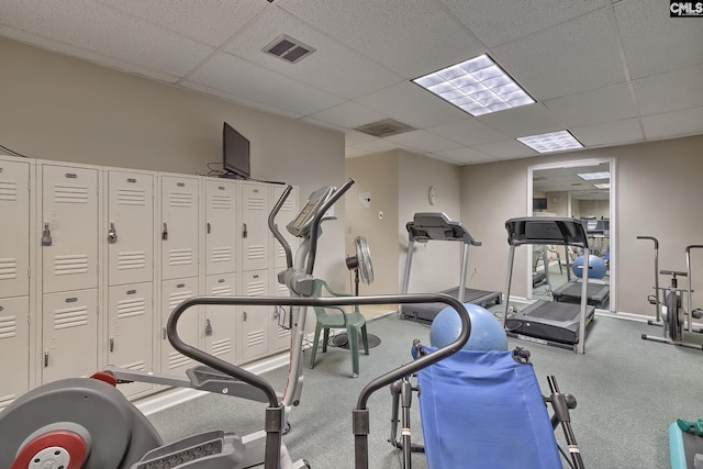 gym with a drop ceiling, visible vents, and baseboards