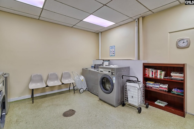 shared laundry area featuring washing machine and dryer and baseboards