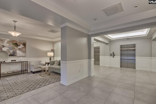 tiled spare room with elevator, a tray ceiling, a wainscoted wall, and ornamental molding