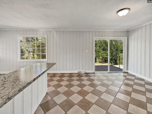 interior space featuring visible vents, crown molding, a textured ceiling, and baseboards