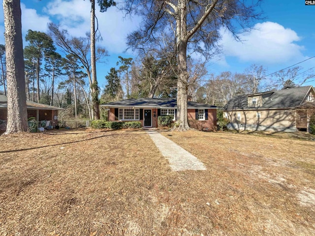 view of front of property featuring brick siding and a front yard