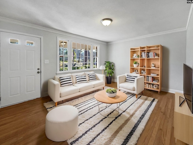 living area featuring baseboards, ornamental molding, and wood finished floors