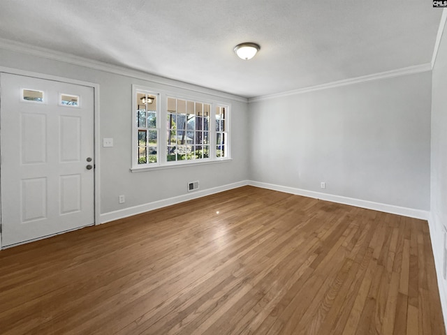 entryway featuring crown molding, visible vents, hardwood / wood-style flooring, and baseboards