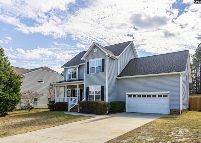 traditional-style house with roof with shingles, a porch, a garage, driveway, and a front lawn