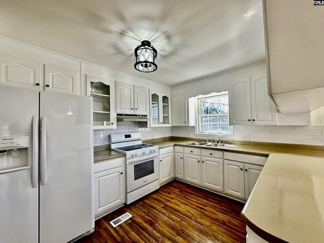 kitchen featuring visible vents, white electric range, under cabinet range hood, refrigerator with ice dispenser, and a sink