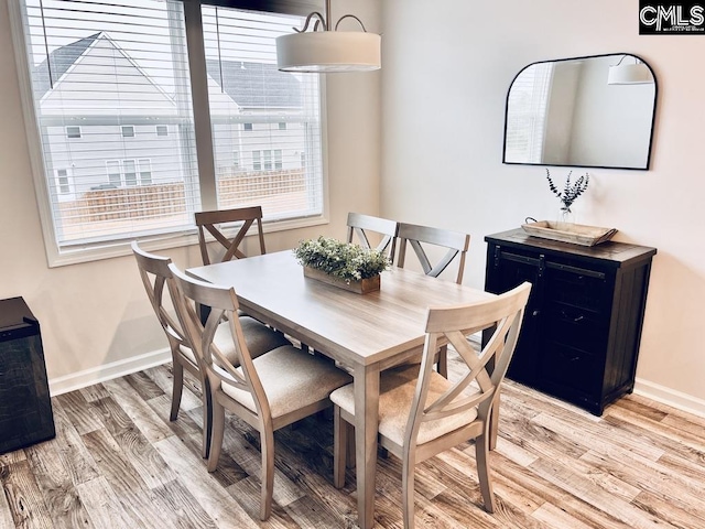 dining area featuring baseboards and light wood-style floors