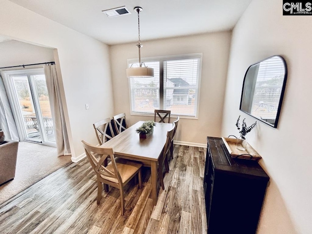 dining area with visible vents, baseboards, and wood finished floors