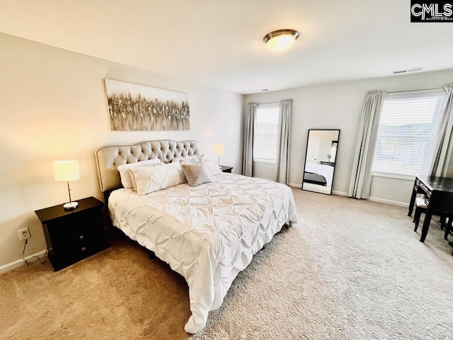 bedroom with light carpet, visible vents, and baseboards