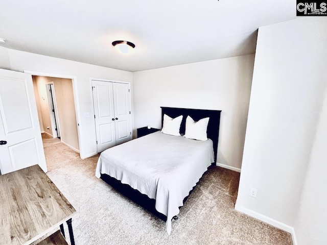 bedroom featuring carpet, a closet, and baseboards