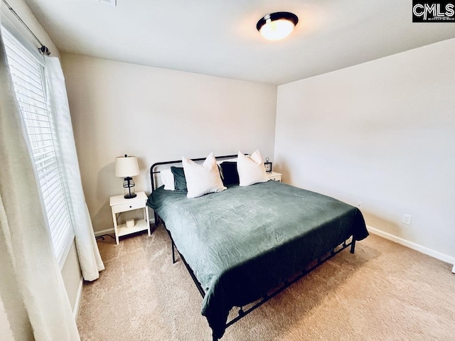 bedroom with multiple windows, carpet flooring, and baseboards