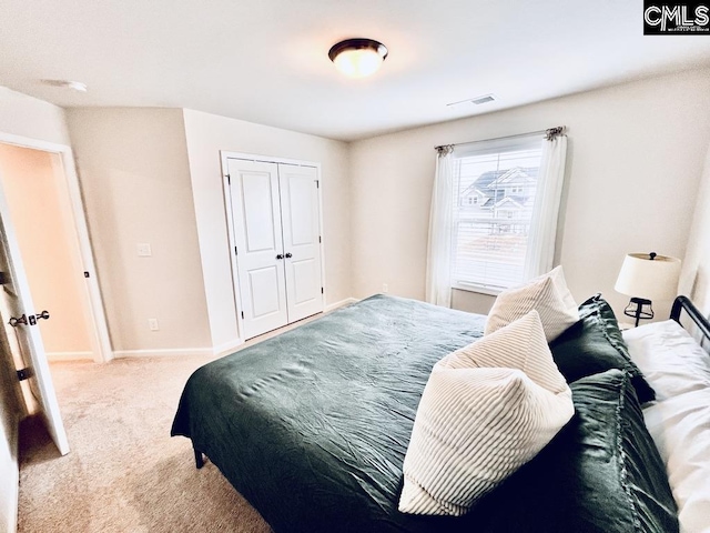 carpeted bedroom featuring baseboards, visible vents, and a closet