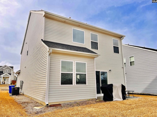 back of house featuring a lawn and cooling unit