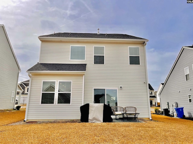 rear view of property featuring a yard and central AC