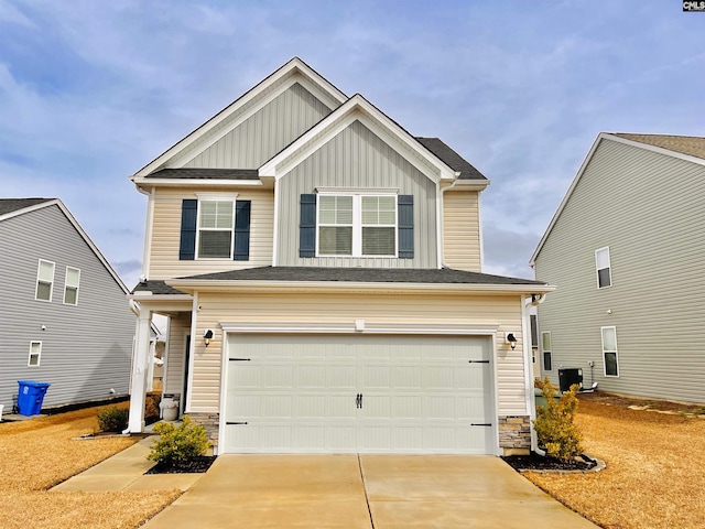 craftsman house featuring an attached garage, central AC, stone siding, concrete driveway, and board and batten siding