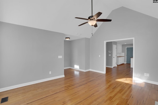 unfurnished room with high vaulted ceiling, ceiling fan, baseboards, and wood finished floors