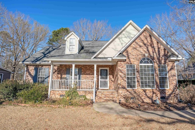 view of front of house with a porch, crawl space, and brick siding