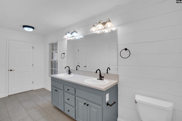 full bath featuring tile patterned floors, a sink, toilet, and double vanity