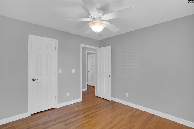 unfurnished bedroom featuring ceiling fan, baseboards, and wood finished floors