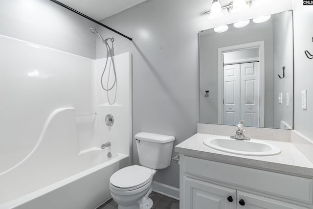 full bathroom featuring washtub / shower combination, baseboards, vanity, and toilet