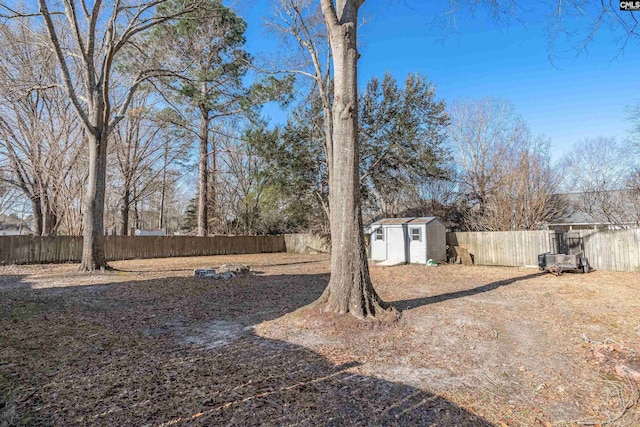 view of yard featuring an outbuilding, a fenced backyard, and a shed