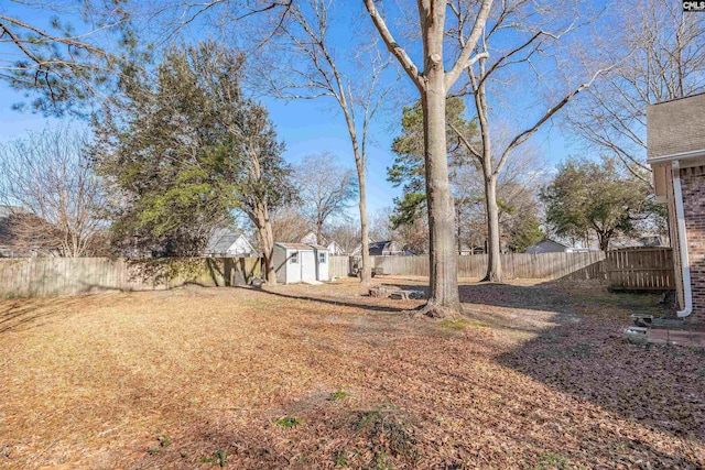 view of yard with a fenced backyard, an outdoor structure, and a storage shed