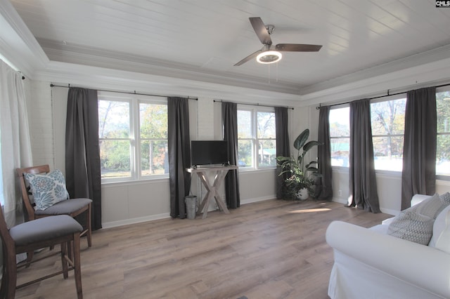 sitting room featuring a healthy amount of sunlight, light wood-style flooring, ornamental molding, and baseboards