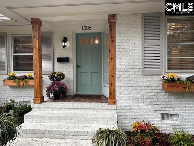 doorway to property with crawl space and brick siding