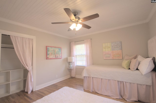 bedroom with a ceiling fan, baseboards, ornamental molding, and wood finished floors