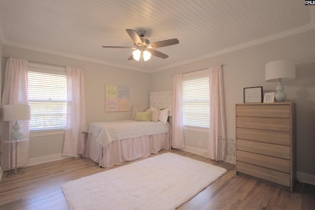 bedroom with crown molding, baseboards, and wood finished floors