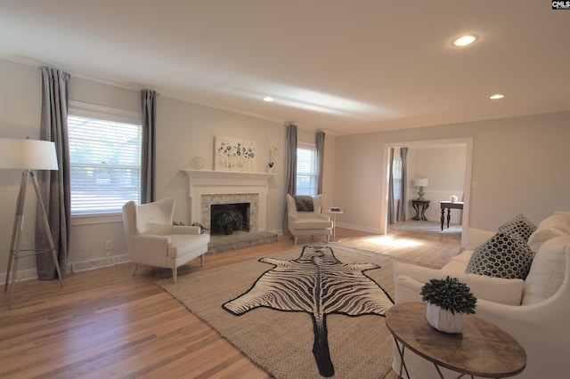 living room with a healthy amount of sunlight, light wood-style floors, a fireplace, and recessed lighting