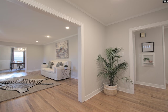 living room featuring light wood-style floors, recessed lighting, ornamental molding, and baseboards