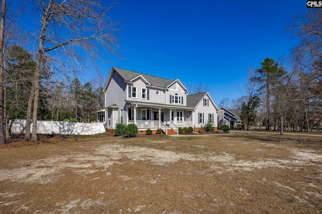 view of front of house with covered porch and fence