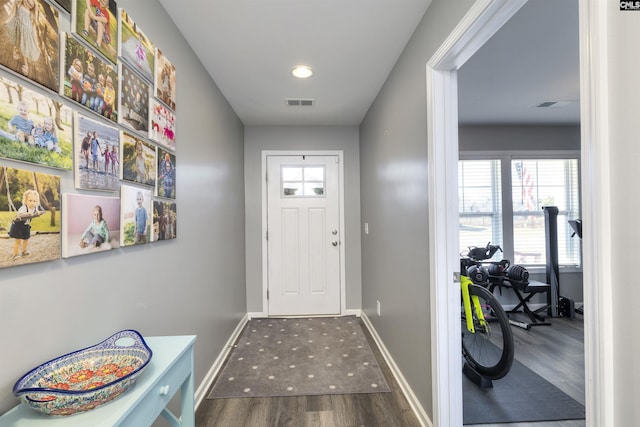 doorway to outside featuring visible vents, baseboards, and wood finished floors