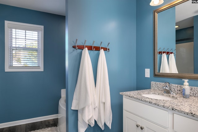 full bathroom with a bath, baseboards, wood finished floors, and vanity