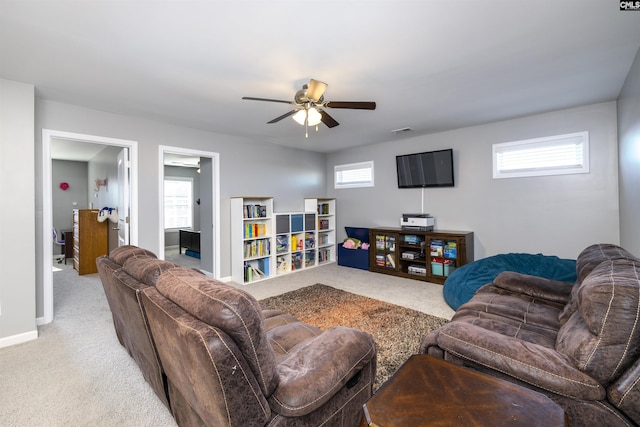 living room with baseboards, a wealth of natural light, and light colored carpet