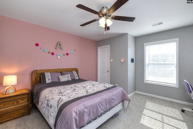 bedroom with light carpet, ceiling fan, visible vents, and baseboards